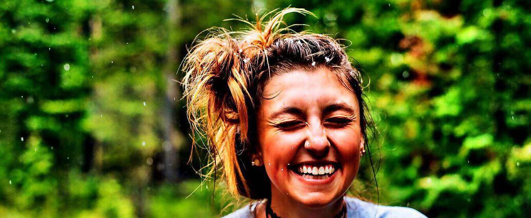 Eine junge Frau, die von Herzen lacht.