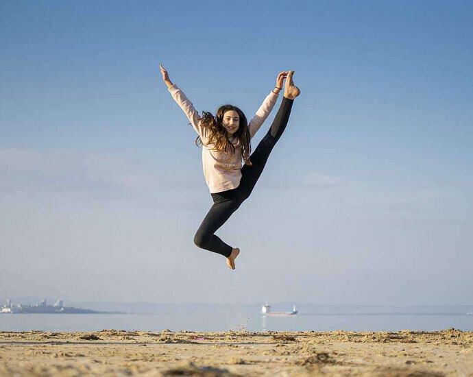 Eine junge Frau, die vor Freude in die Luft springt.