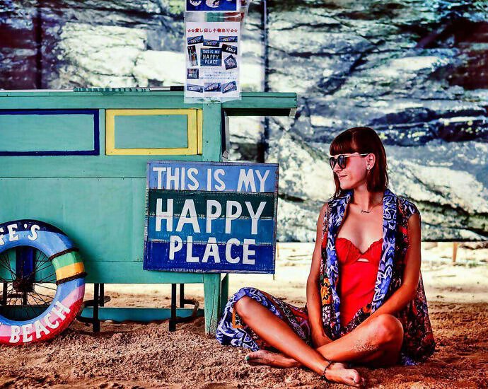 Entspannt sitzt eine Frau im Schneidersitz auf dem Boden.