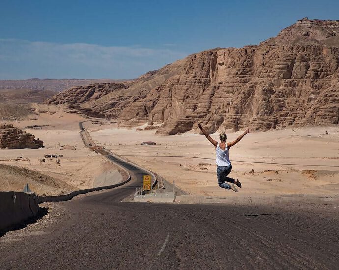 Ein Bild von einer jungen Frau, die vor Freude in die Luft springt.