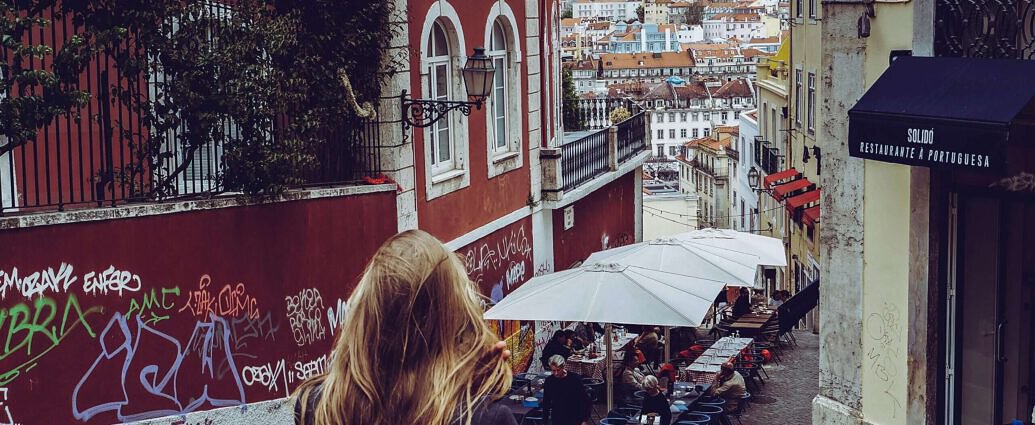 Eine junge Frau geht ins Café in der Alfama
