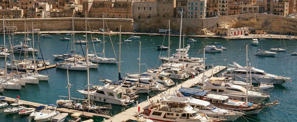 Ein Bild von Malta mit Gebäuten und daneben das Meer.