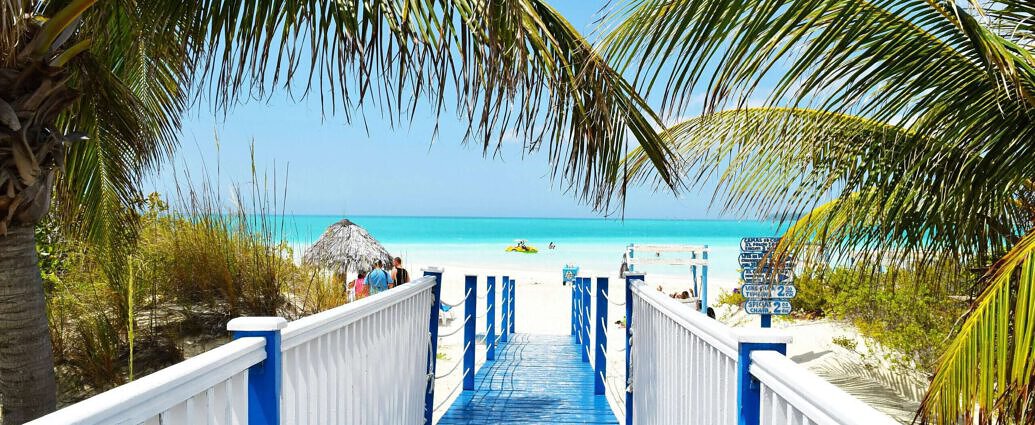 Ein Bild von Kubas Sreand mit weisen Strand und Palmen.