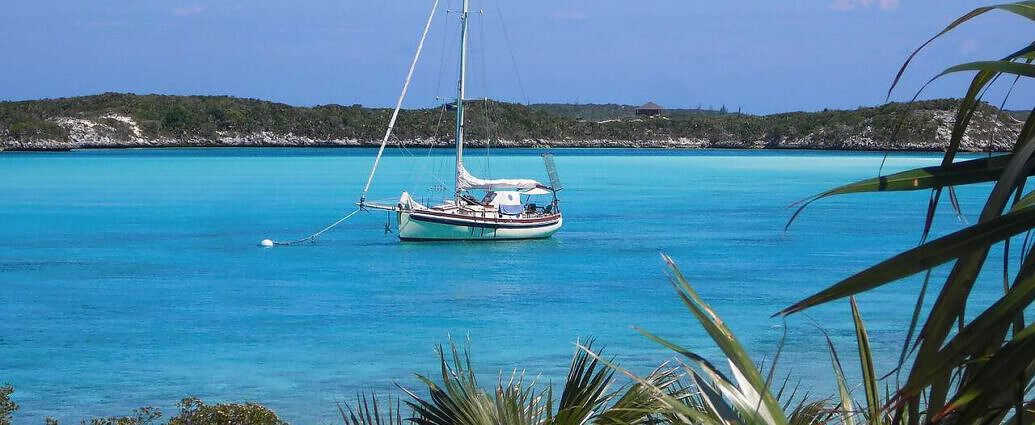 Ein Bild von den Bahamas mit schöner Landschaft, Meer und einem Segelboot.