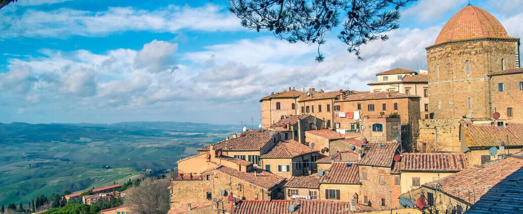 Ein Landschaftsbild von Volterra in der Toskana mit seinen Hügeln und alten Gebäuden.