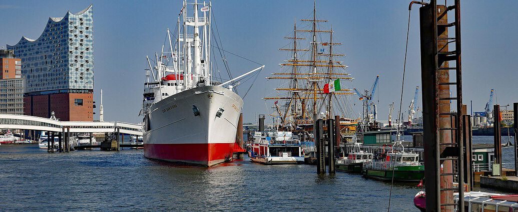 Ein Bild vom Hamburger Hafen mit Elbphilharmonie und Schiffen.