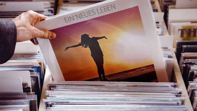 Eine Männerhand holt aus einen Stapel eine LP heraus