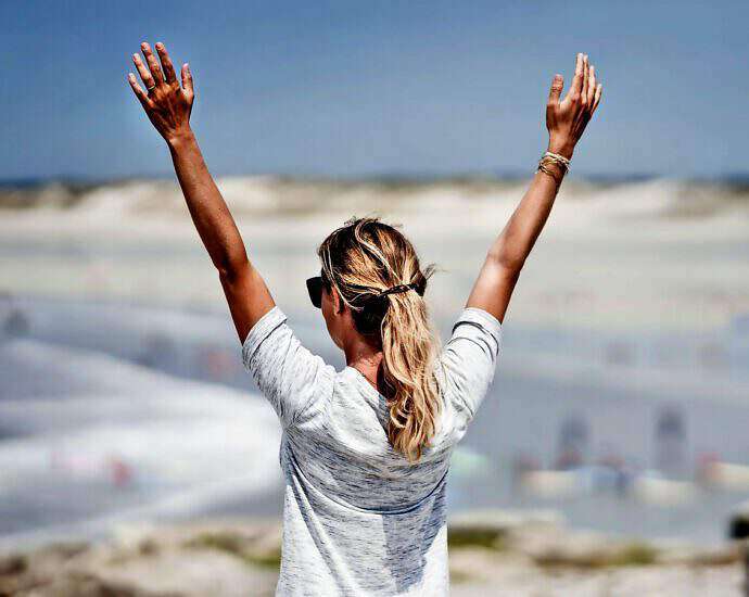 Eine Frau die ihre Arme zum Sieg nach oben streckt