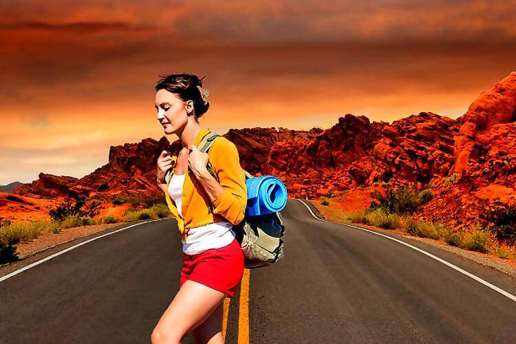 Eine junge Wanderin überquert eine Straße