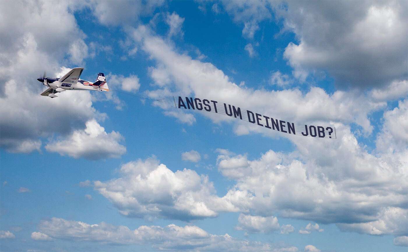 Ein Flugzeug mit einen Banner mit der Aufschrift: Was tun bei Angst um deinen Job?