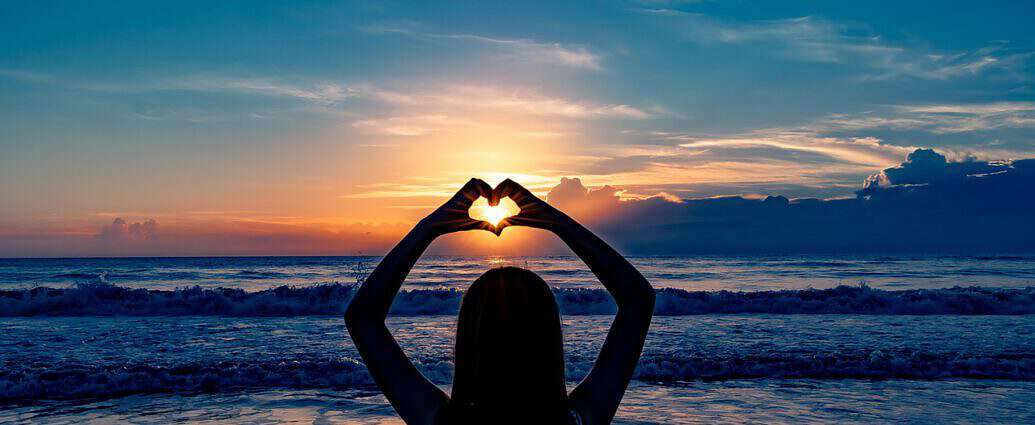 Frau zeigt mit ihren Händen ei Herz in der Luft