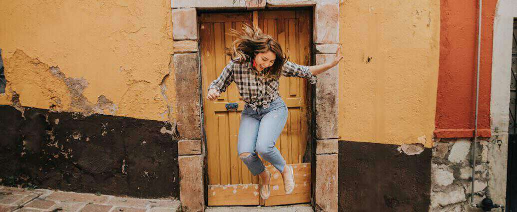 Eine junge Frau springt vor Freude in die Luft.