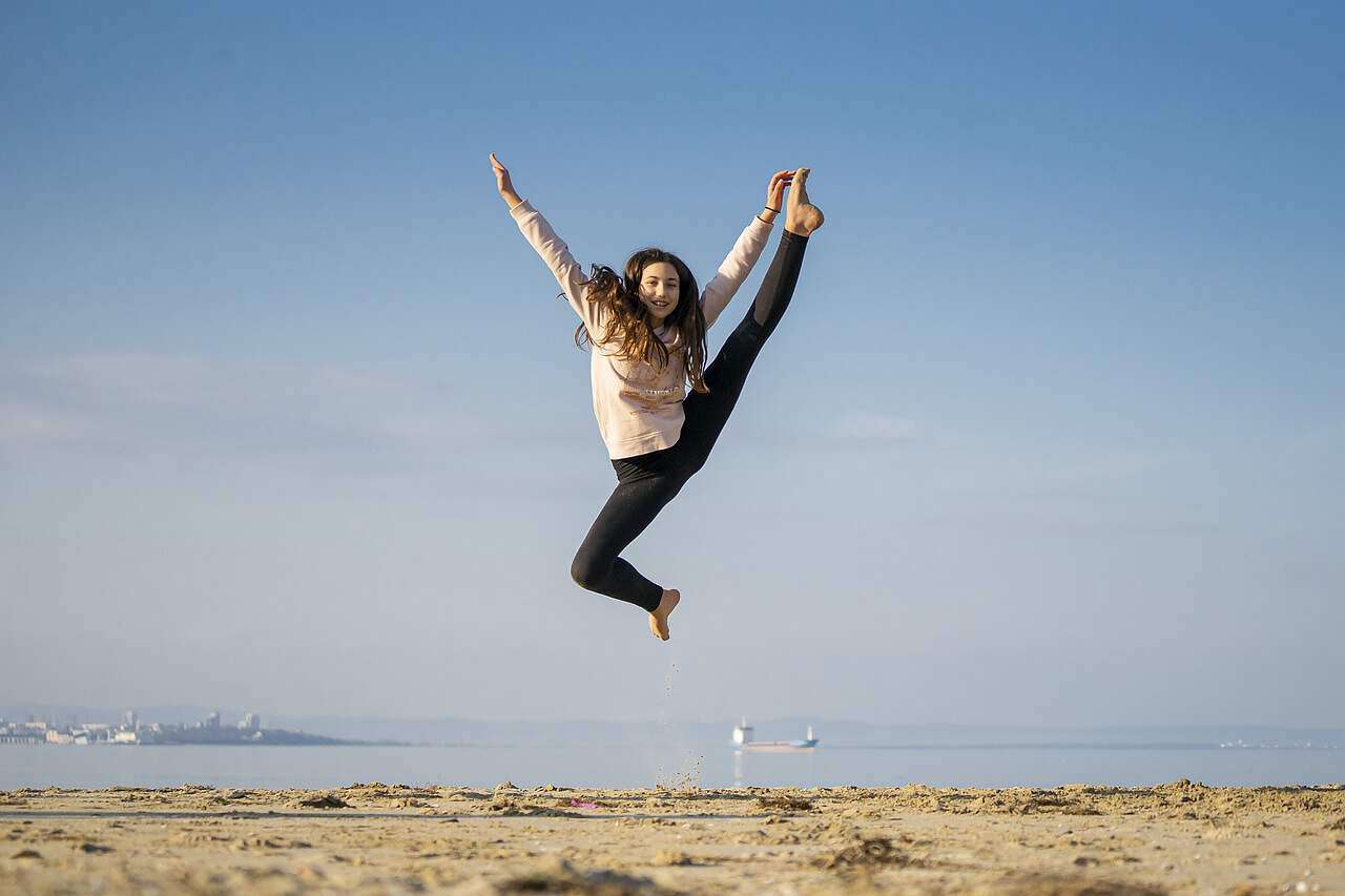 Eine junge Frau, die vor Freude in die Luft springt.