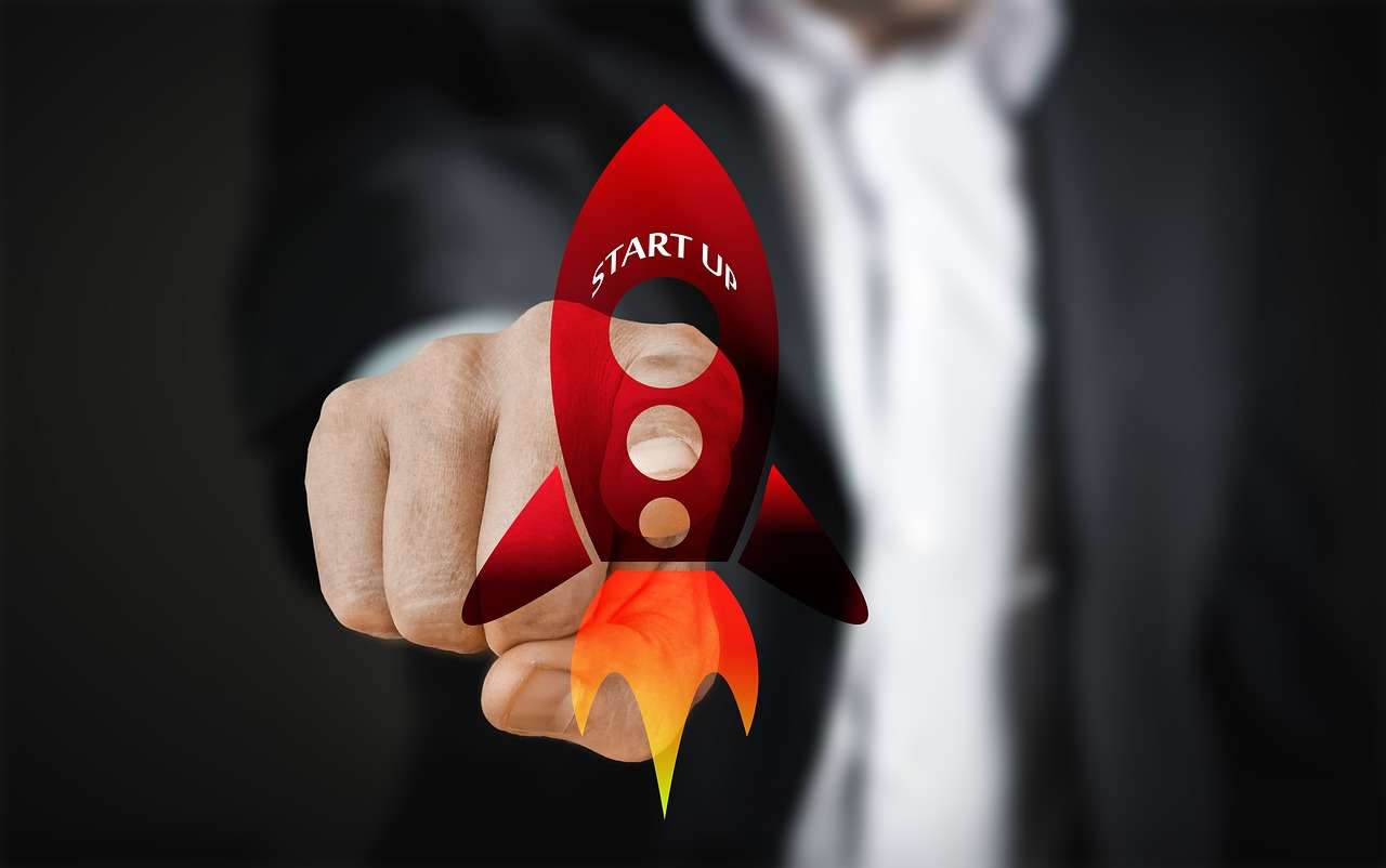 Ein im Anzug gekleideter Manager, der mit dem Finger auf eine Rakete zeigt.