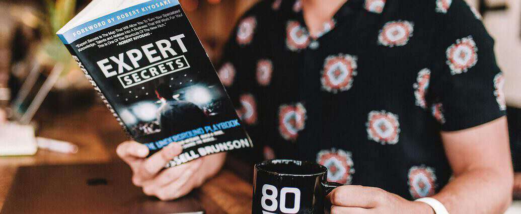 Ein junger Mann hält ein Erfolgsbuch in der Hand.