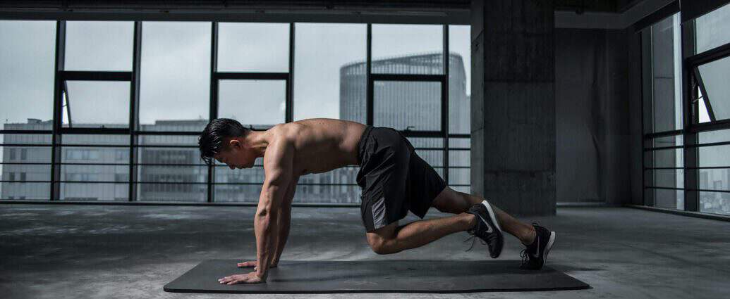 Ein muskulöser junger Mann beim Sport auf einer Yogamatte.