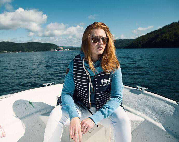 Eine junge Frau die in eine Bot fährt und entspannt vor sich her träumt.