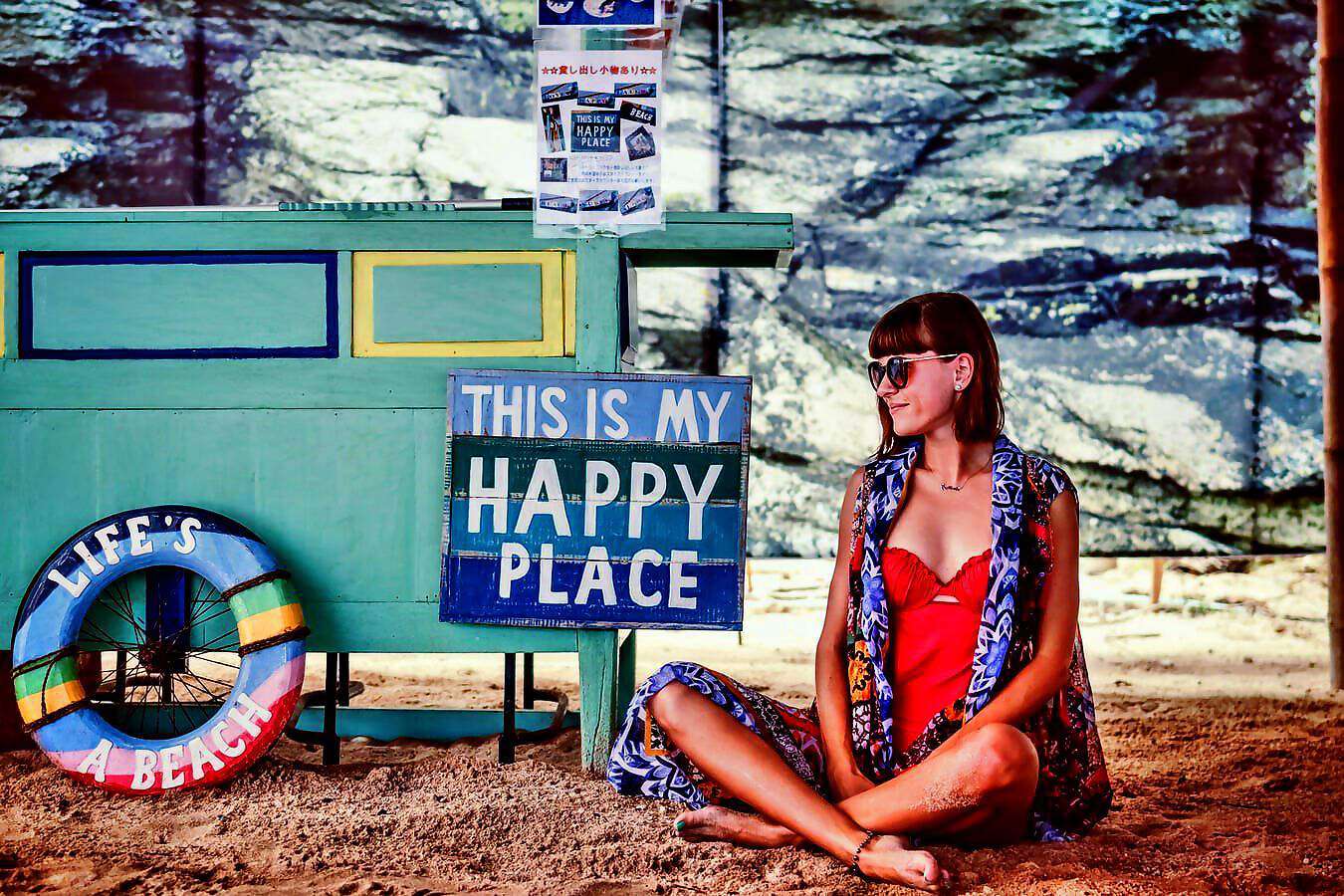 Entspannt sitzt eine Frau im Schneidersitz auf dem Boden.