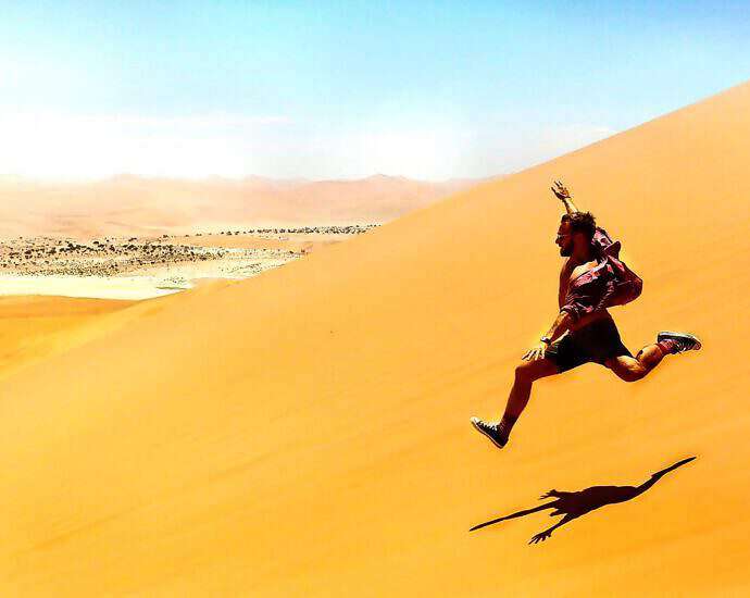 Ein Mann, der schnell eine Düne hinunterrennt.