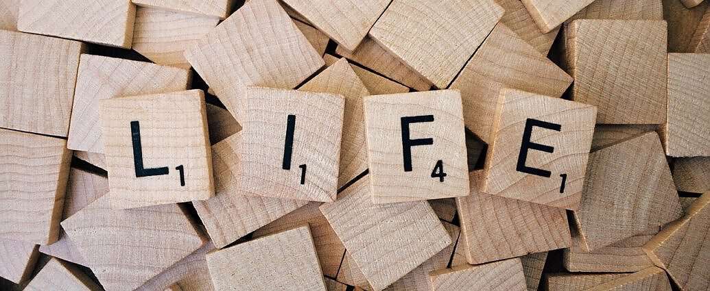 Ein Bild mit Scriple-Steinen aus Holz mit der Aufschrift „LIFE”.