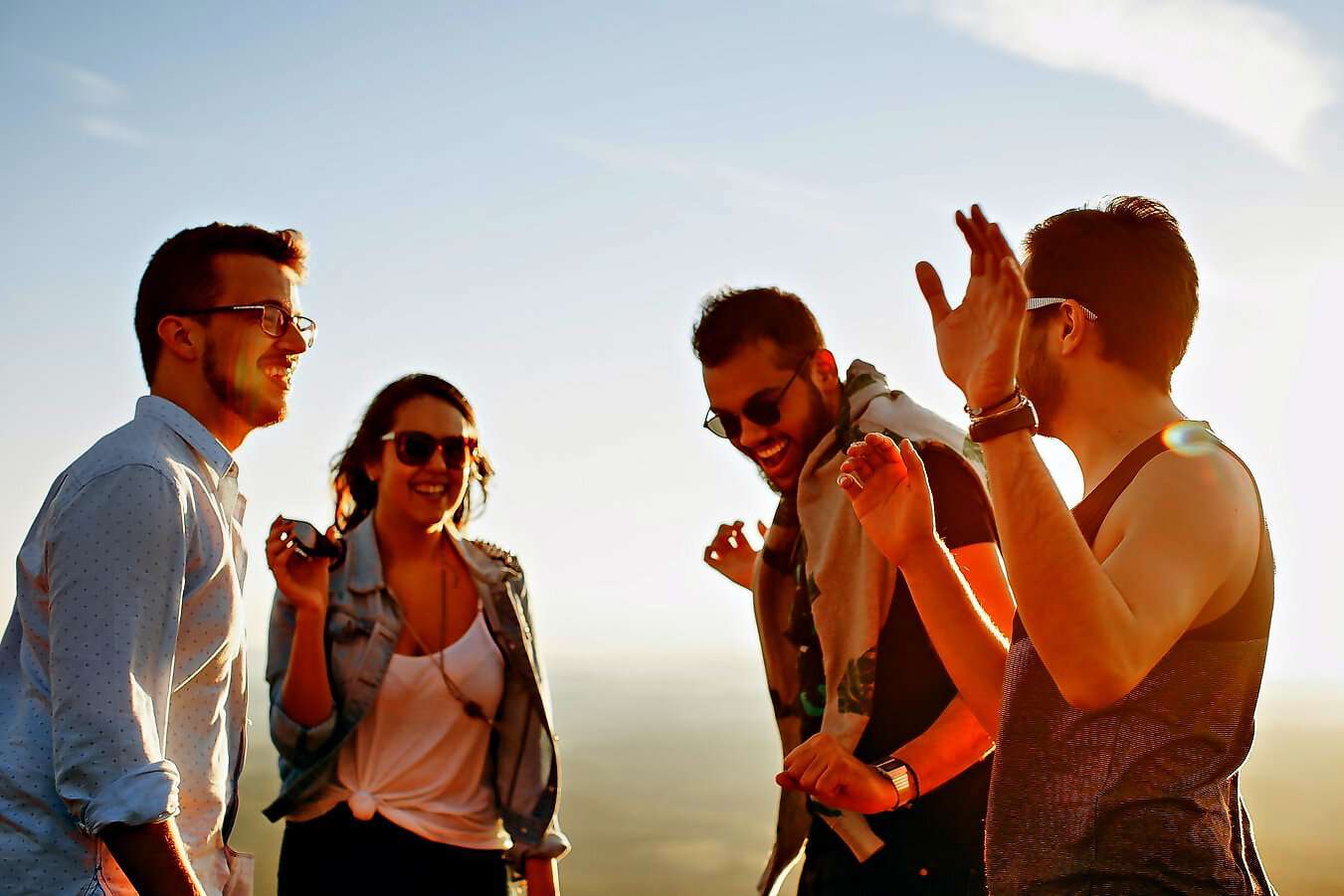 Das Bild zeigt vier junge Menschen, die sich freudig unterhalten.