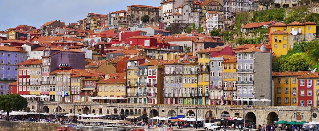 Ein Stadtbild Portugals mit seinen bunten Häusern und dem Hafen.